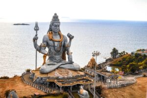 A stunning aerial view of the Murudeshwara Temple with the iconic Shiva statue by the sea.